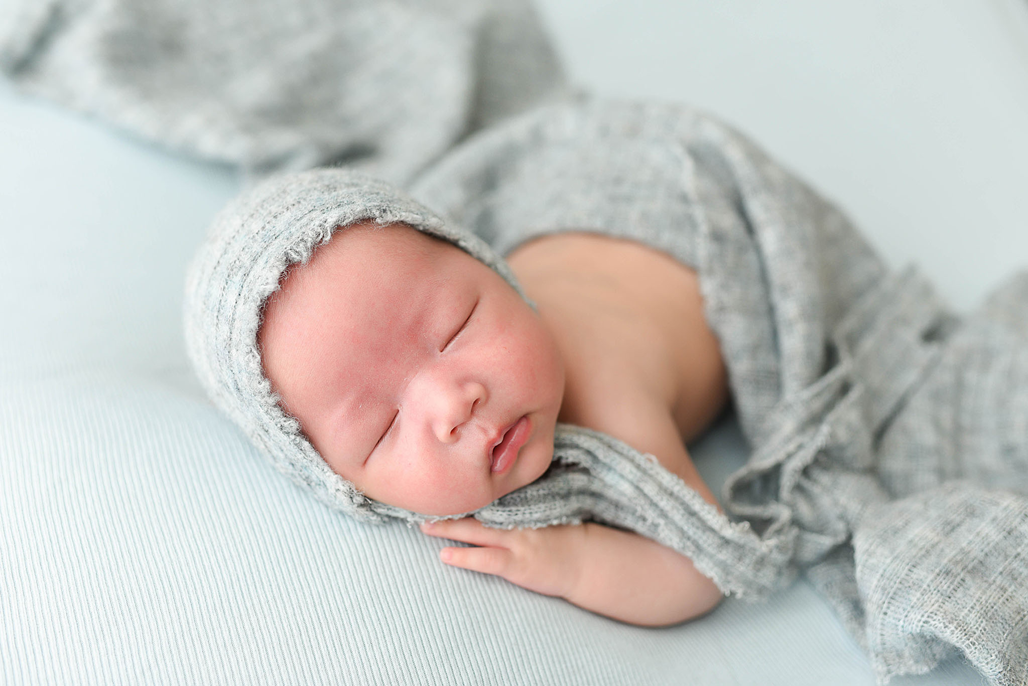 A newborn baby sleeps on its tummy in a bonnet childbirth classes jacksonville fl