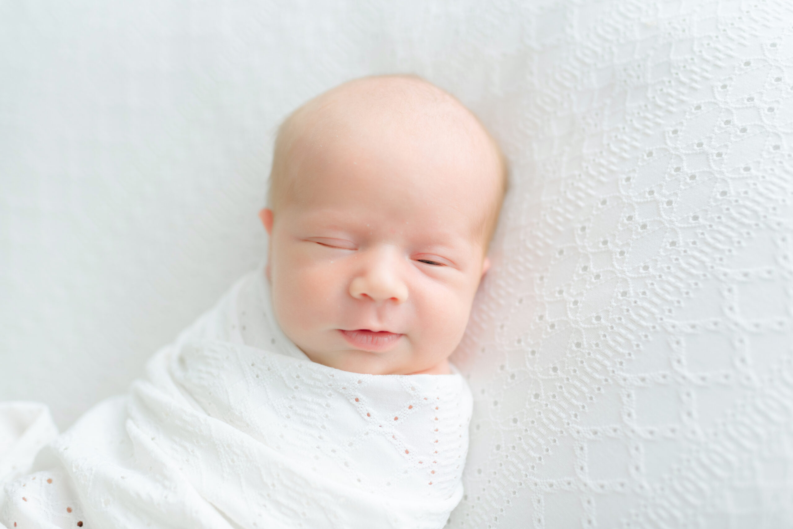 Newborn girl in Jacksonville newborn photography studio lying peacefully on white blanket