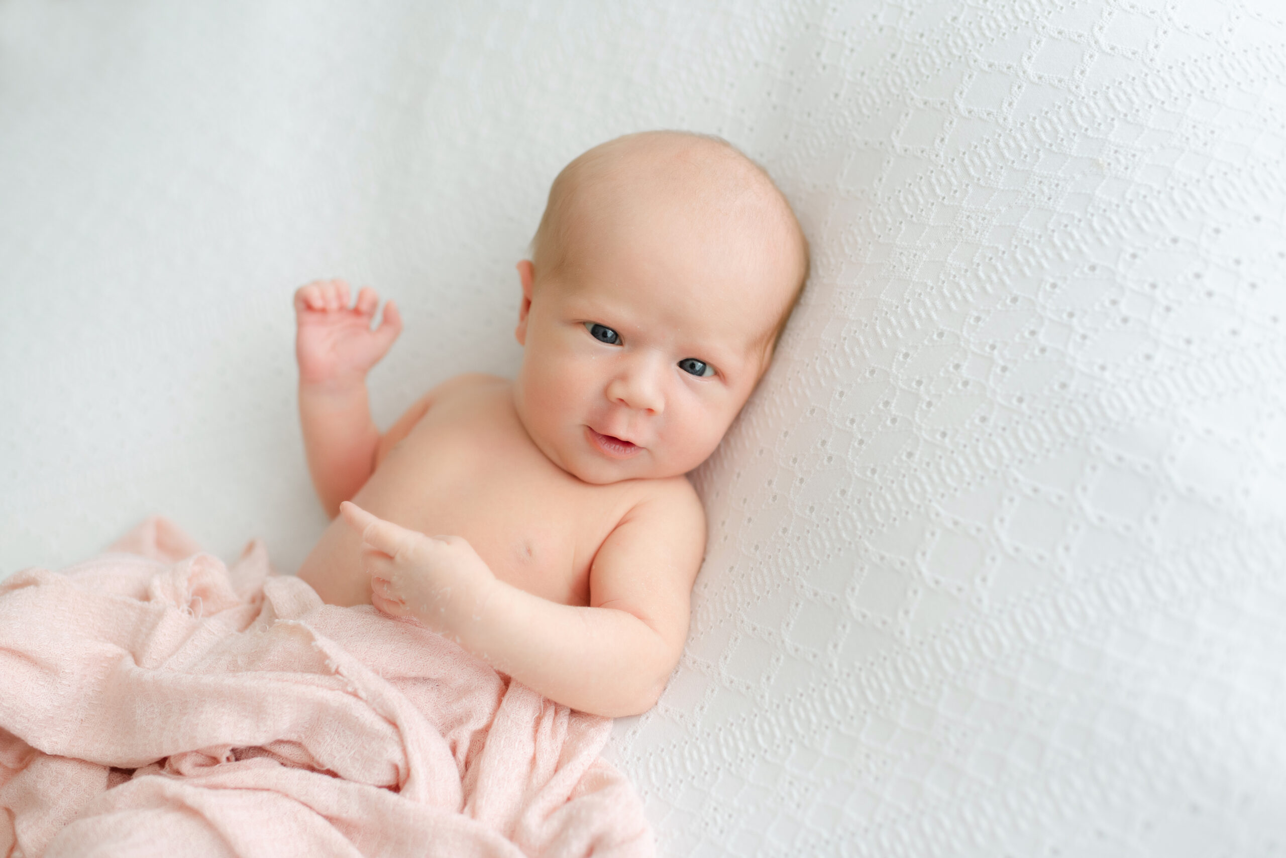Newborn baby wrapped in soft pink blanket at Jacksonville newborn photography studio