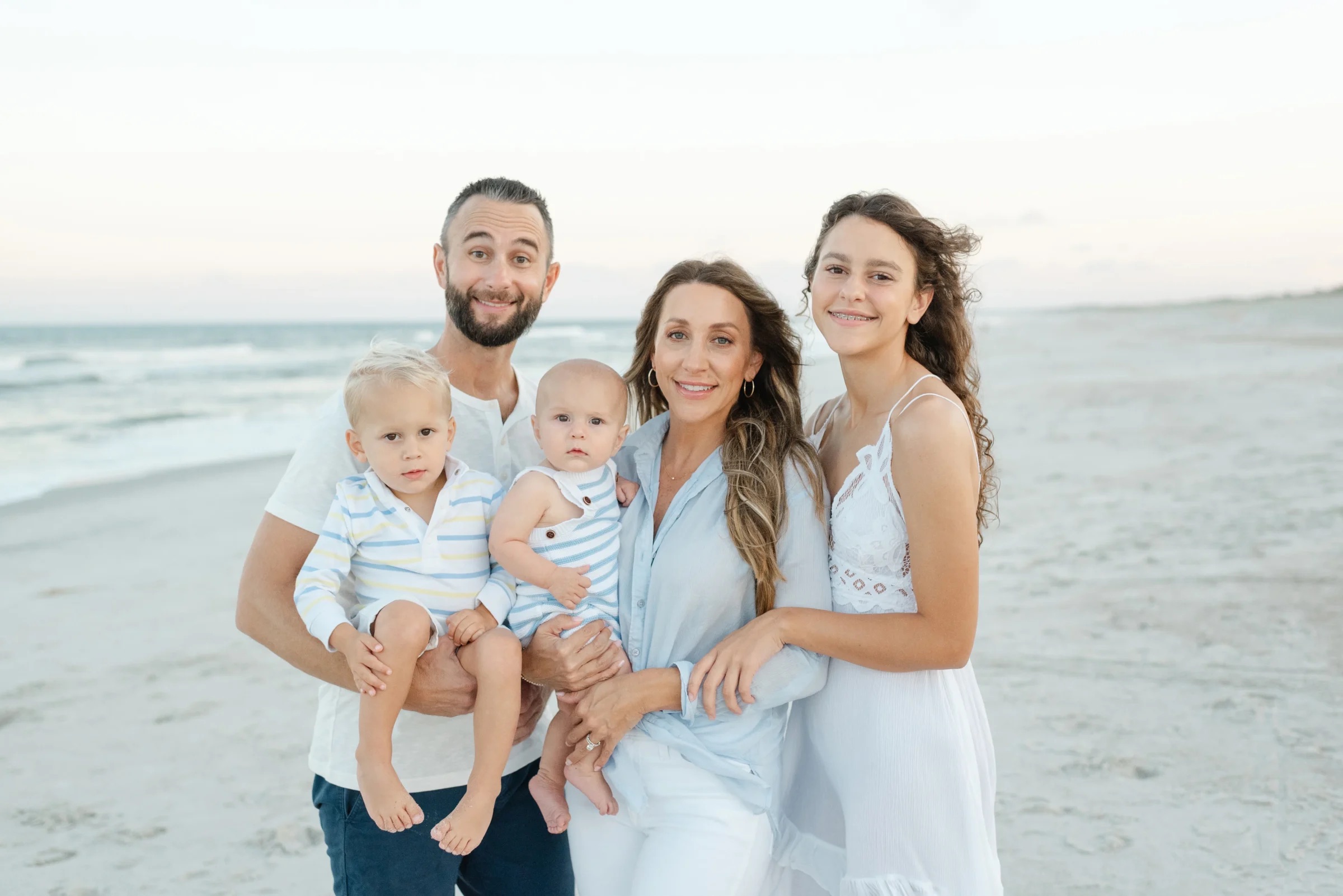 A family with a mom, dad, and three kids at a photo session.