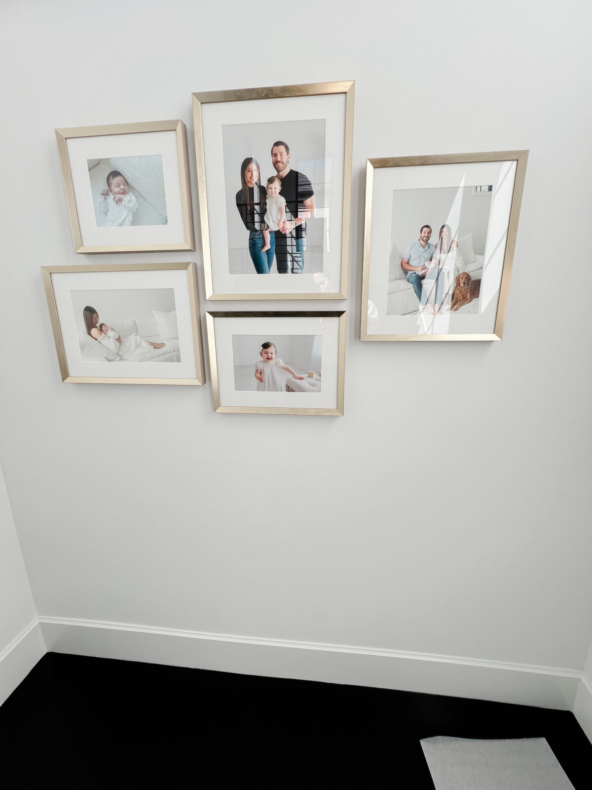 Installation of a newborn and first birthday session framed wall gallery