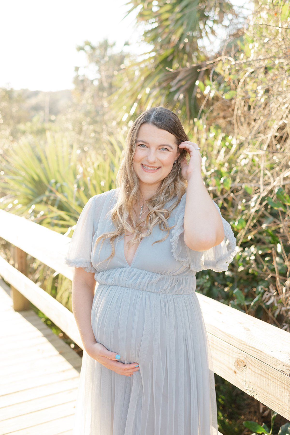mom to be smiling and holding her baby bump