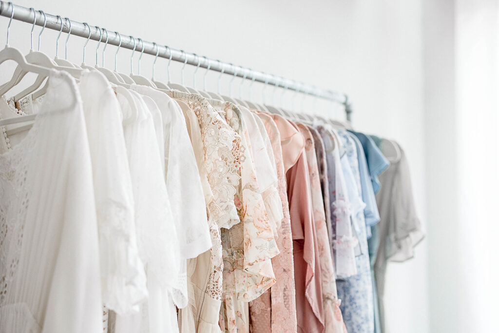 a clothing rack full of soft color maternity dresses