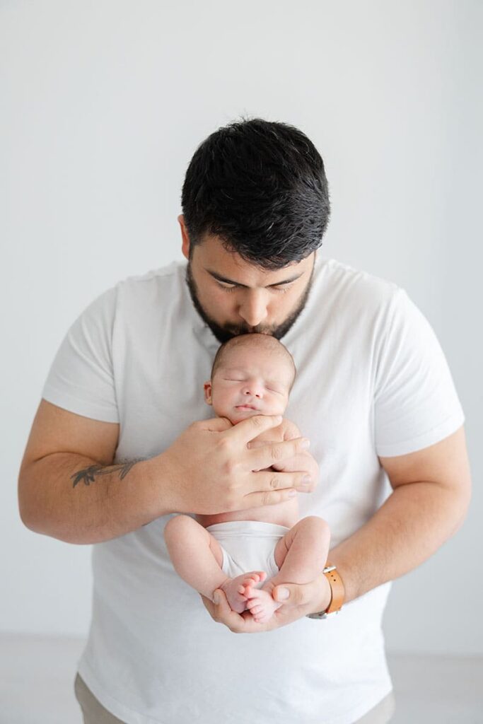 Newborn photographer in Jacksonville featuring dad holing baby
